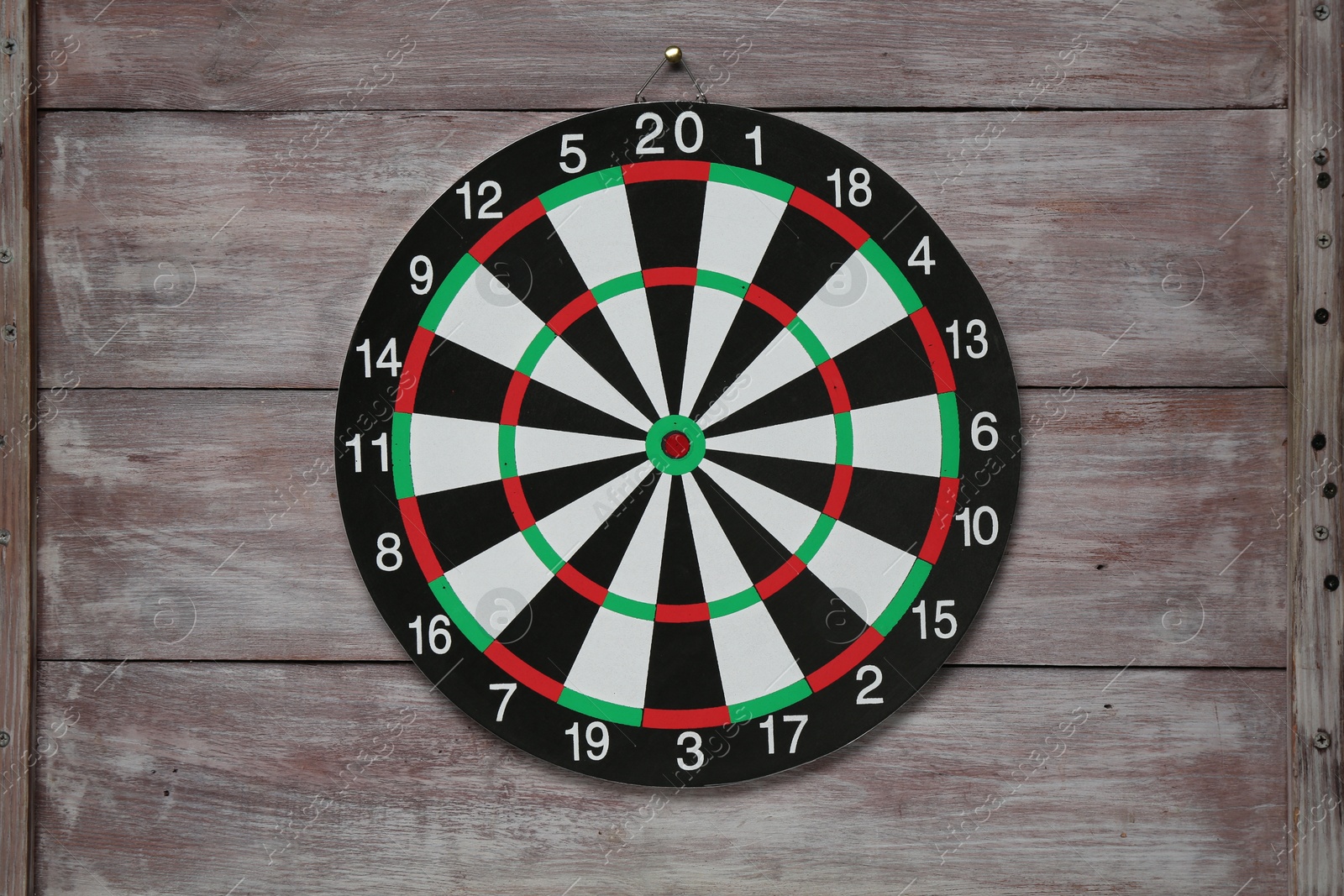 Photo of One dart board hanging on wooden rustic background