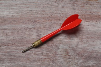 Photo of Red dart arrow on wooden rustic table, top view