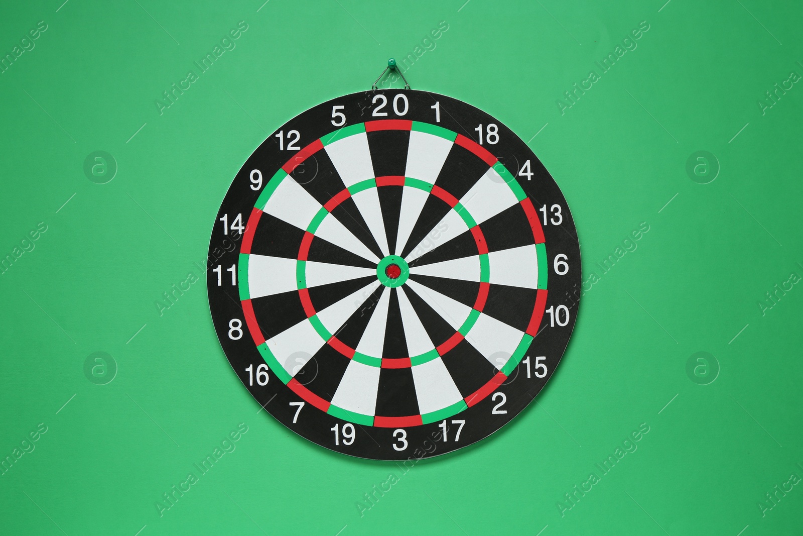 Photo of One dart board hanging on green wall