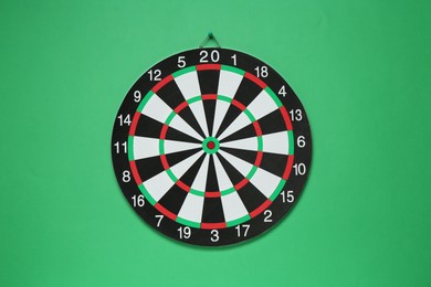 Photo of One dart board hanging on green wall