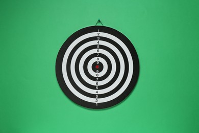 Photo of One dart board hanging on green wall