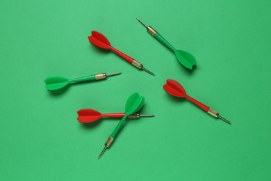 Photo of Colorful dart arrows on green background, flat lay