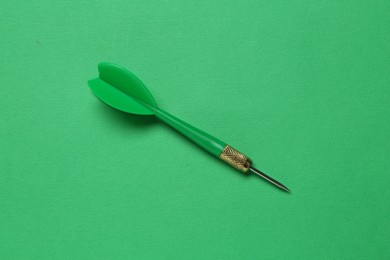 Photo of One dart arrow on green background, top view