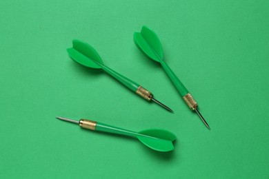 Photo of Dart arrows on green background, flat lay