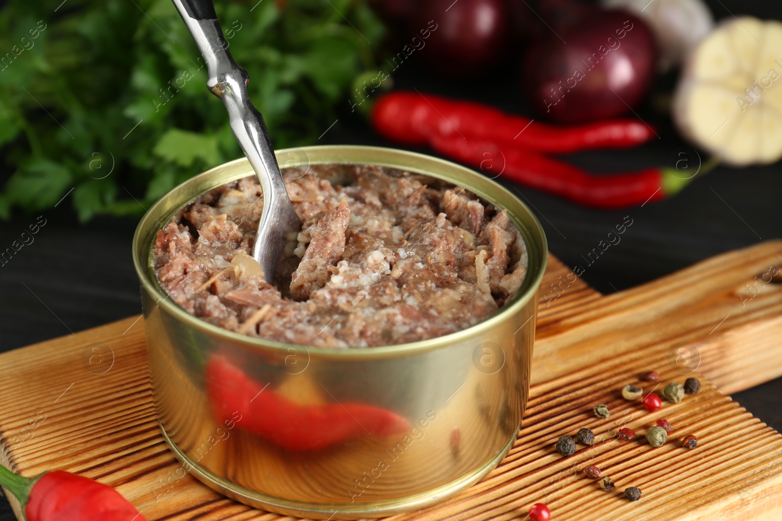 Photo of Canned meat in tin can and spices on table, closeup