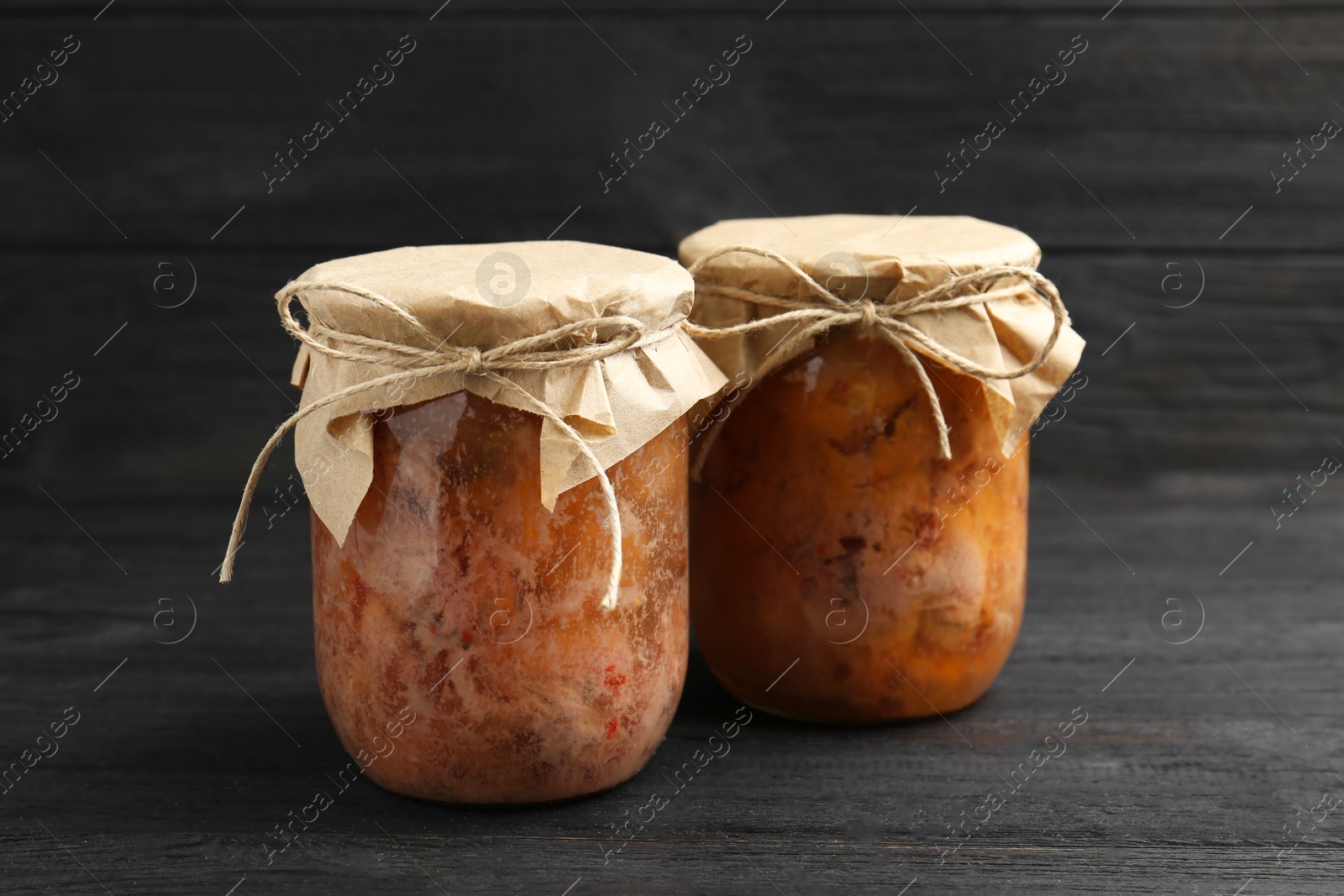 Photo of Canned meat in glass jars on wooden table