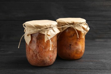 Photo of Canned meat in glass jars on wooden table