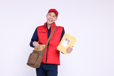 Photo of Happy postman with bag and envelopes on white background