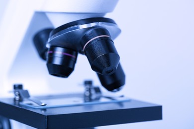 Photo of Science. Microscope with glass slide on light grey background, closeup