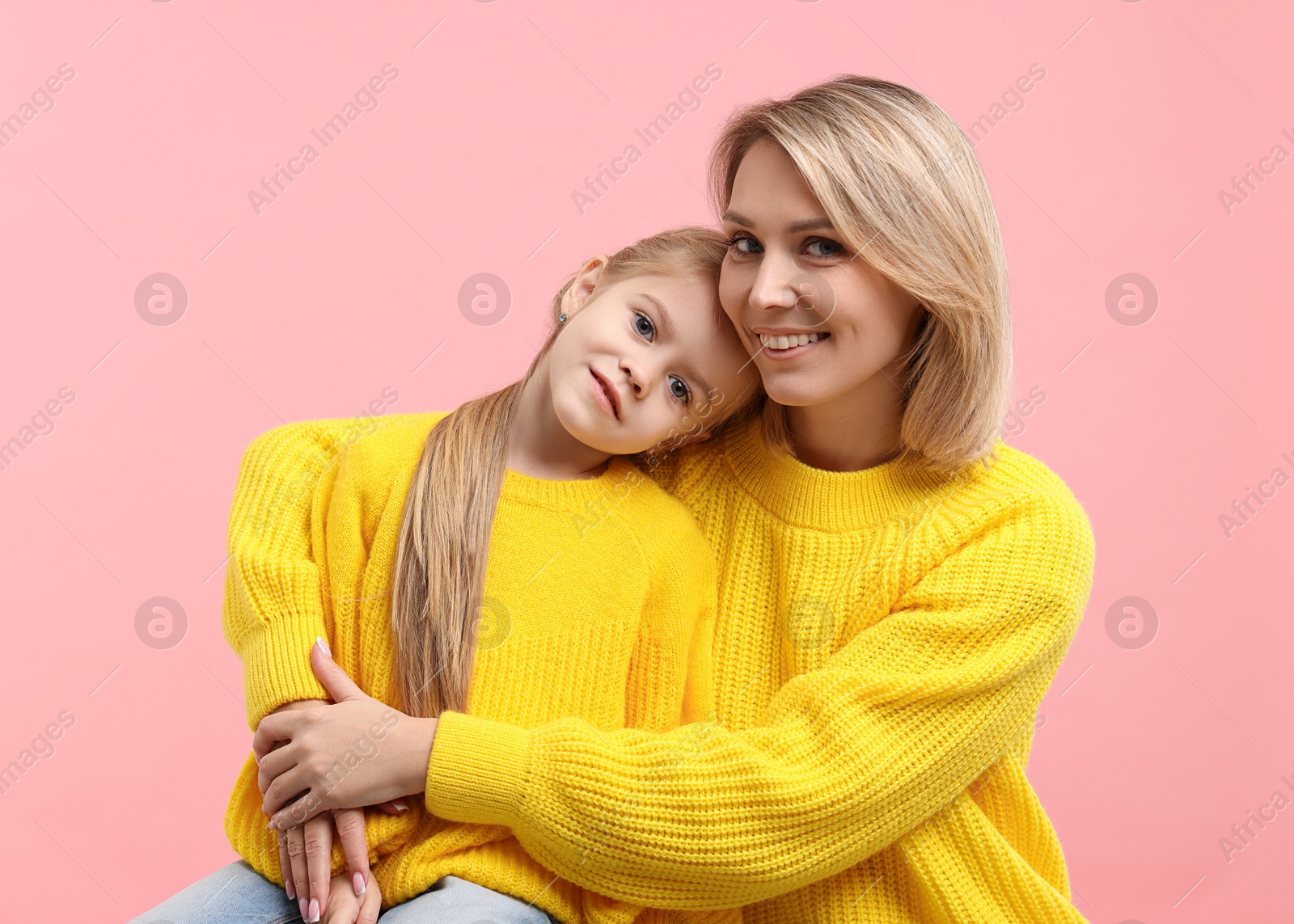 Photo of Cute little girl with her mom on pink background. Happy Mother's Day