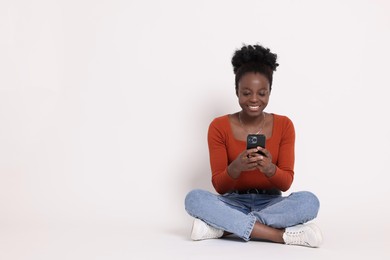 Happy woman with smartphone on white background. Space for text