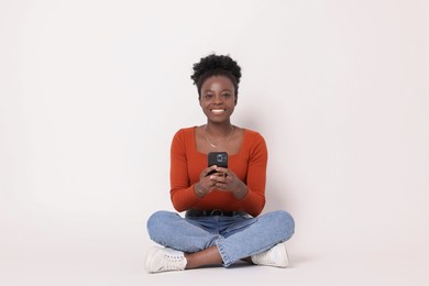 Photo of Happy woman with smartphone on white background