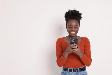 Photo of Happy woman with smartphone on white background. Space for text