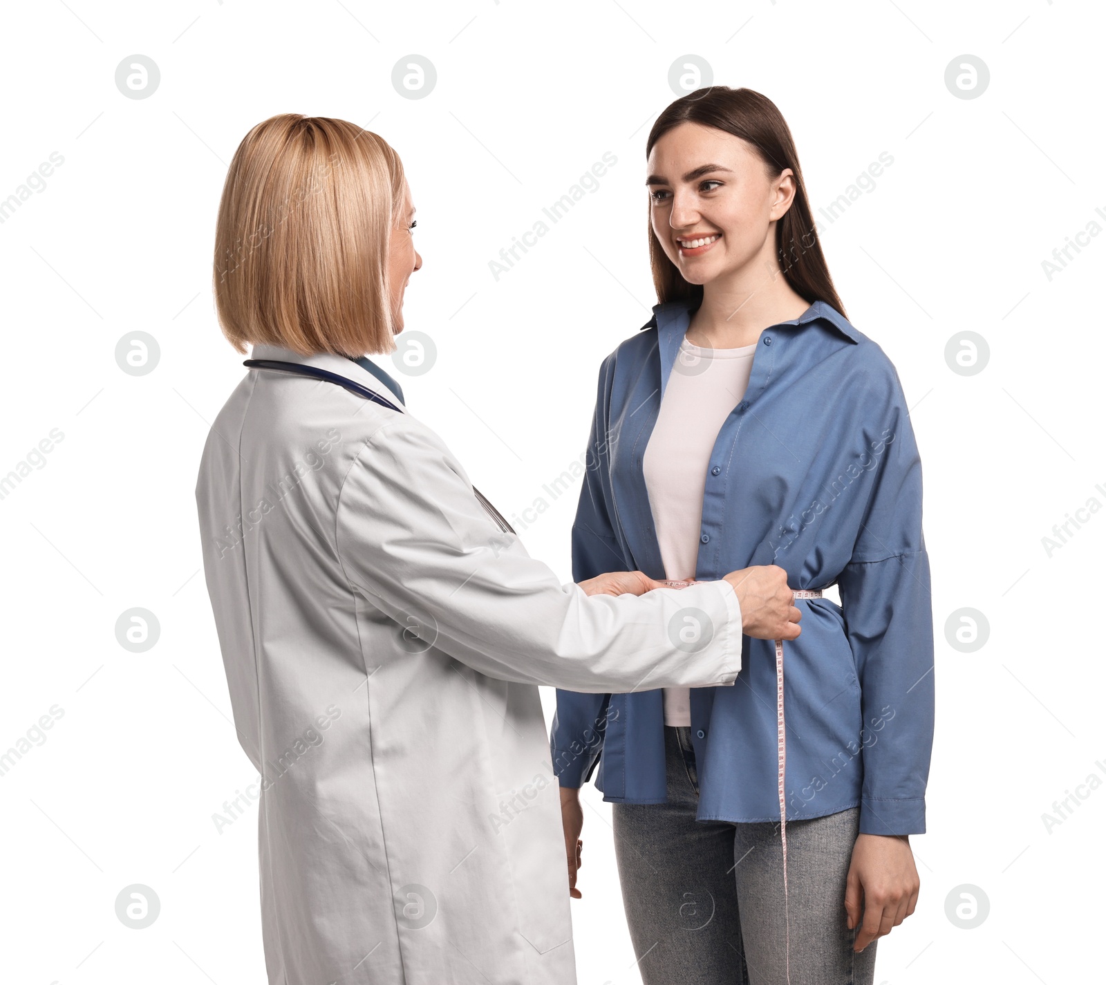 Photo of Weight loss. Nutritionist measuring patient's waist with tape on white background