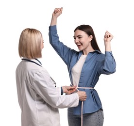 Happy woman lost weight. Nutritionist measuring patient's waist with tape on white background