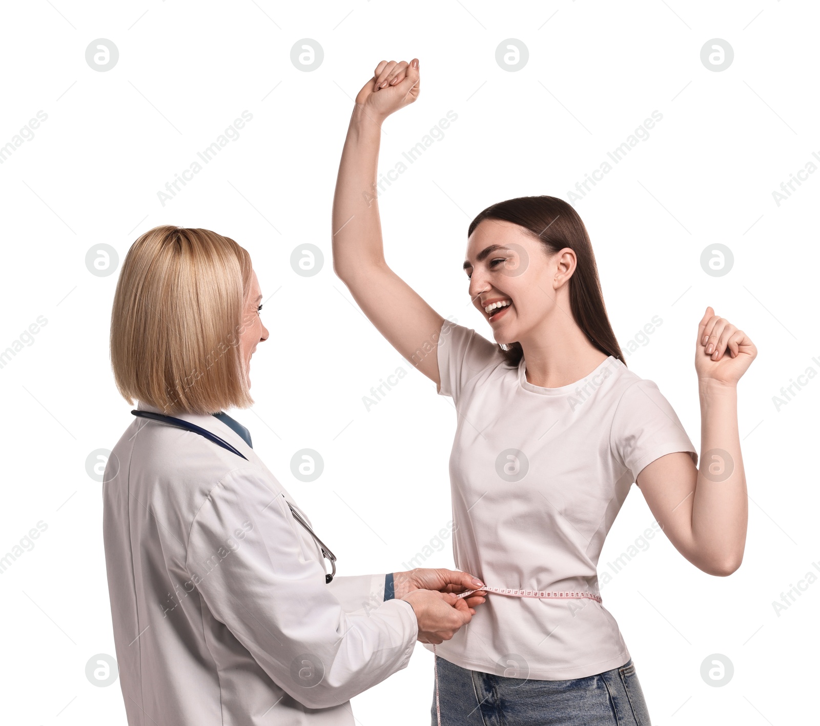 Photo of Happy woman lost weight. Nutritionist measuring patient's waist with tape on white background