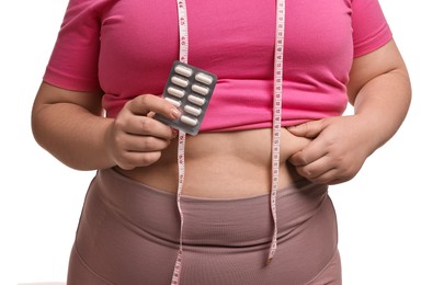 Photo of Plus size woman holding blister of weight loss supplements on white background, closeup