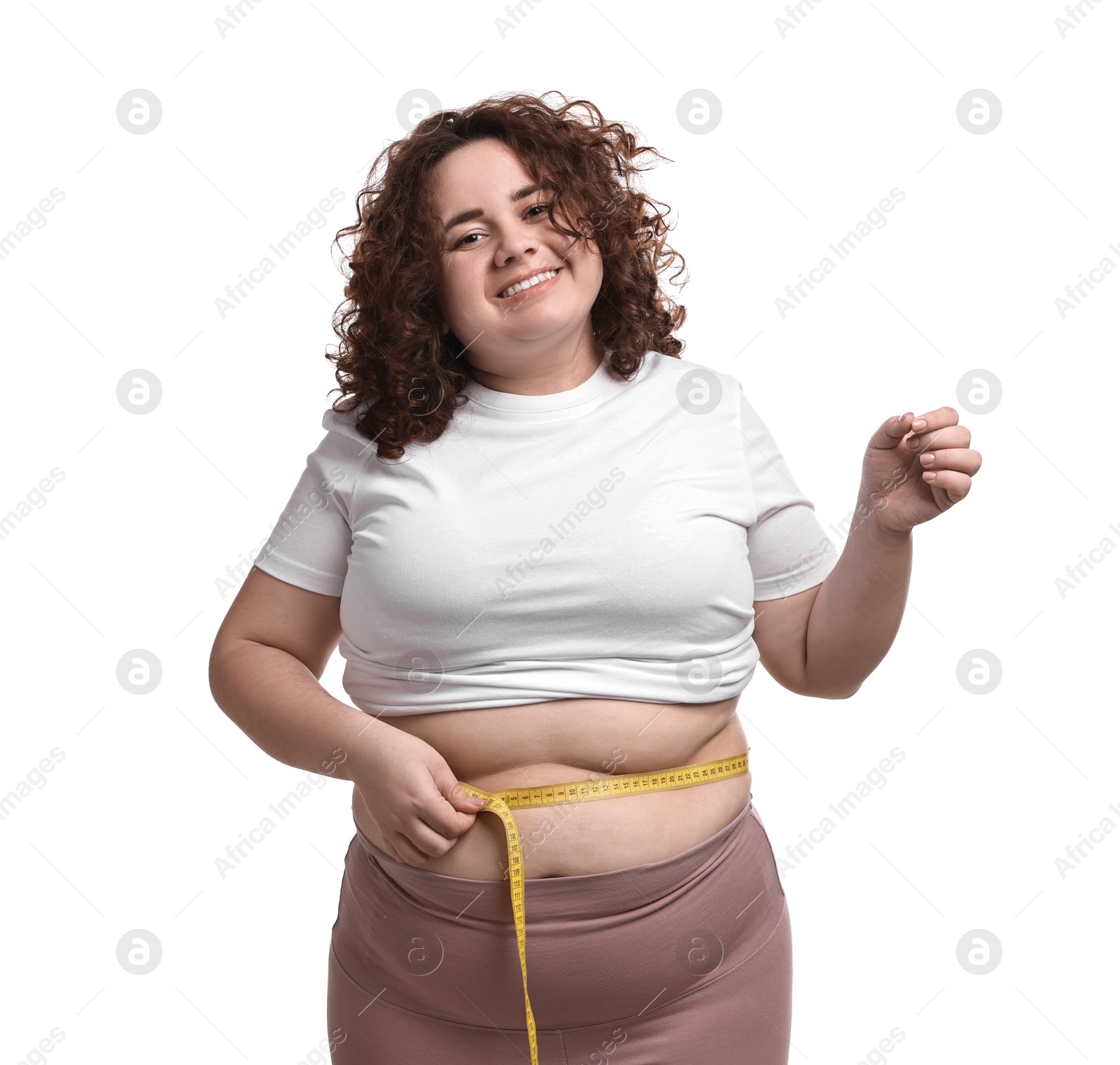 Photo of Weight loss. Happy plus size woman measuring waist with tape on white background