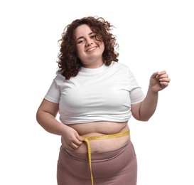 Photo of Weight loss. Happy plus size woman measuring waist with tape on white background