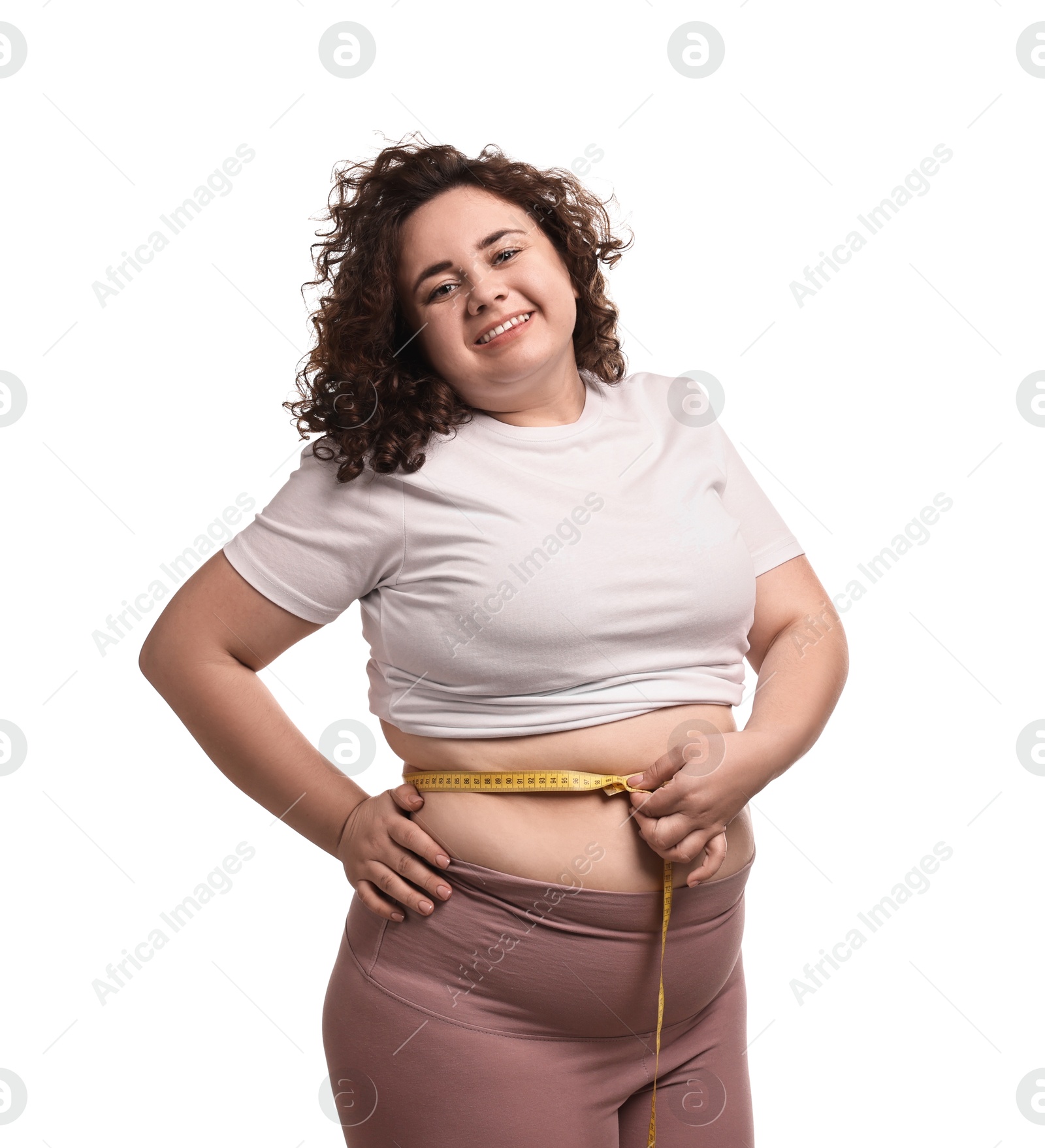 Photo of Weight loss. Happy plus size woman measuring waist with tape on white background