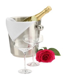 Photo of Bottle of champagne in ice bucket, beautiful rose and empty glasses isolated on white