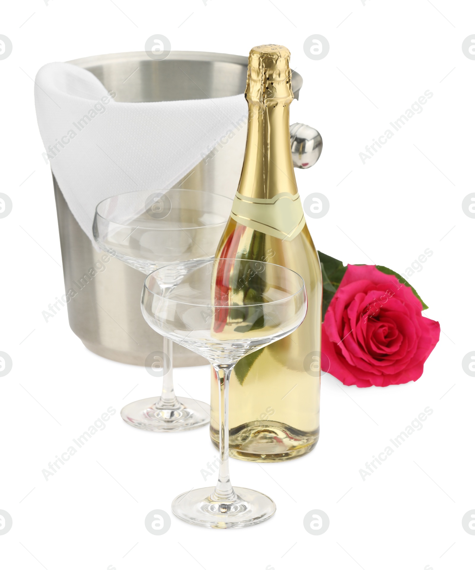 Photo of Bottle of champagne, glasses, beautiful rose and ice bucket isolated on white