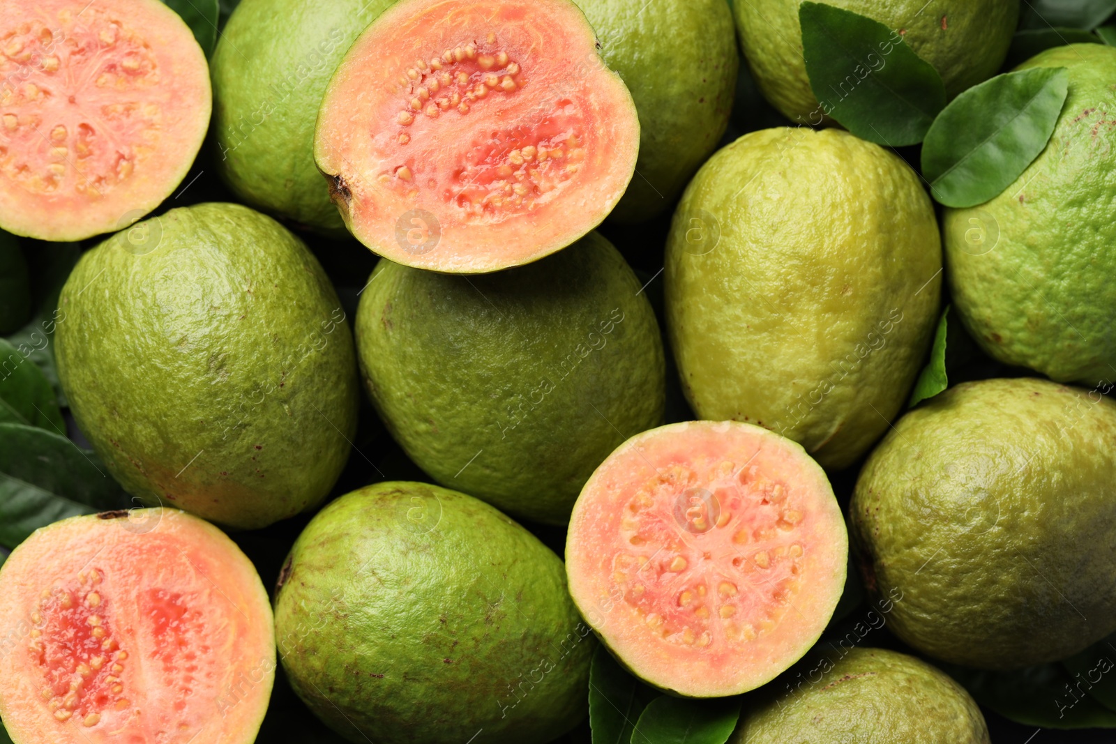 Photo of Fresh cut and whole guava fruits as background, top view