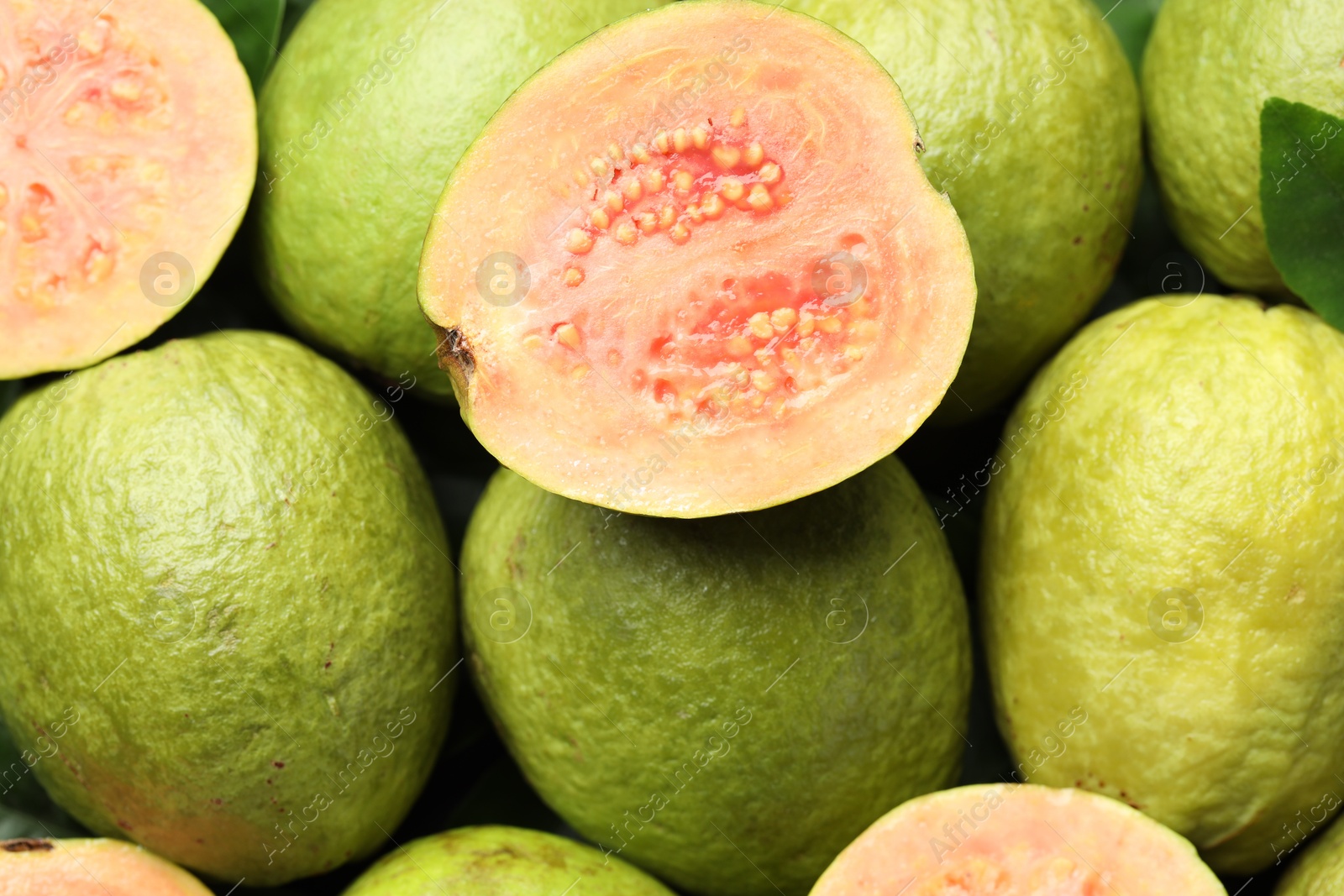 Photo of Fresh cut and whole guava fruits as background, above view