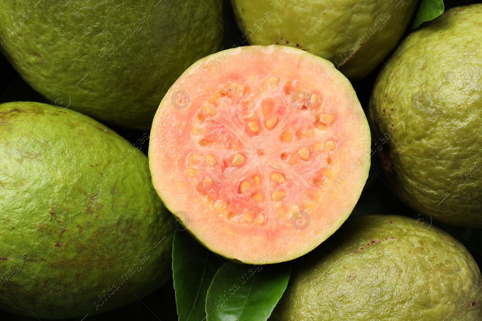 Photo of Fresh cut and whole guava fruits as background, top view