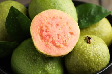 Photo of Fresh guava fruits with water drops in bowl, closeup