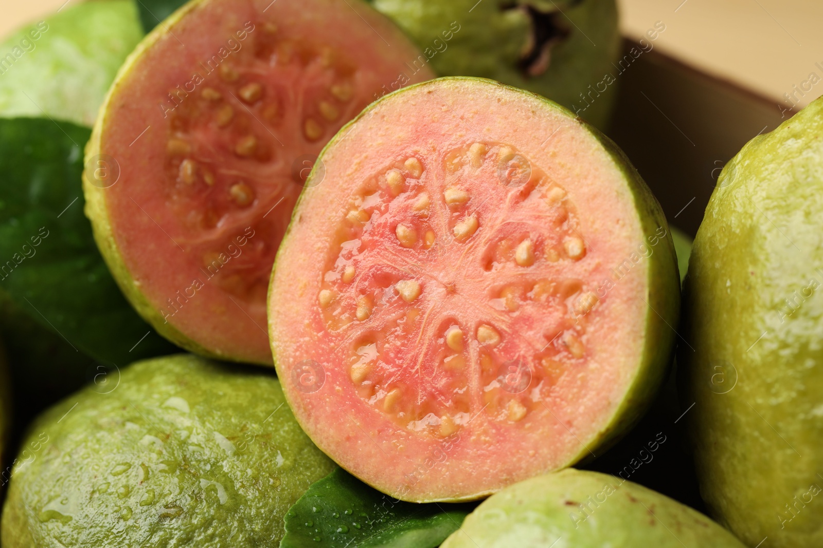 Photo of Fresh cut and whole guava fruits, closeup