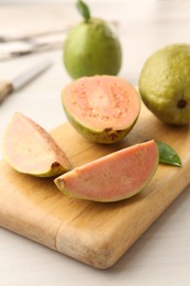 Photo of Fresh guava fruits on white wooden table, closeup