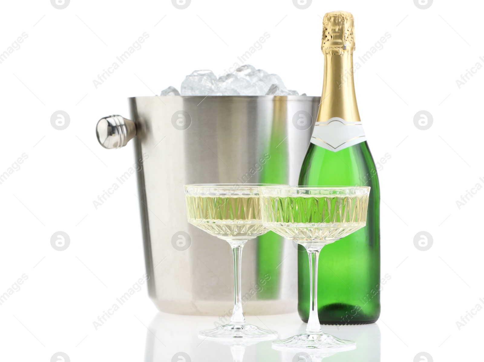 Photo of Champagne in glasses, bottle and ice bucket isolated on white