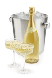 Photo of Champagne in glasses, bottle and ice bucket isolated on white