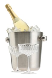 Photo of Bottle of champagne in ice bucket and empty glasses isolated on white