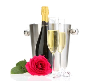 Photo of Champagne in glasses, bottle, beautiful rose and ice bucket isolated on white