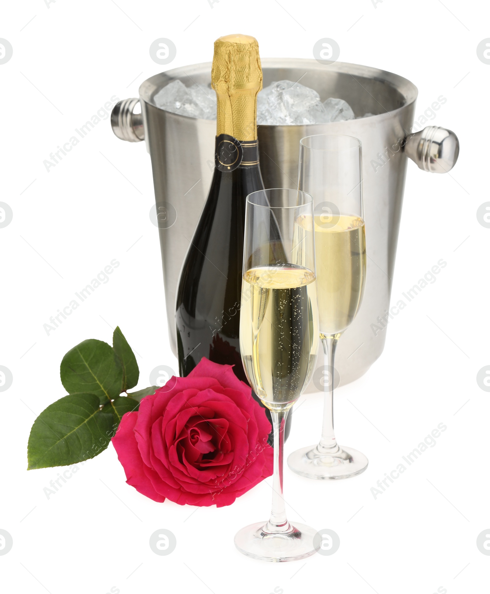 Photo of Champagne in glasses, bottle, beautiful rose and ice bucket isolated on white