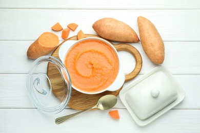 Photo of Delicious sweet potato soup served on white wooden table, flat lay