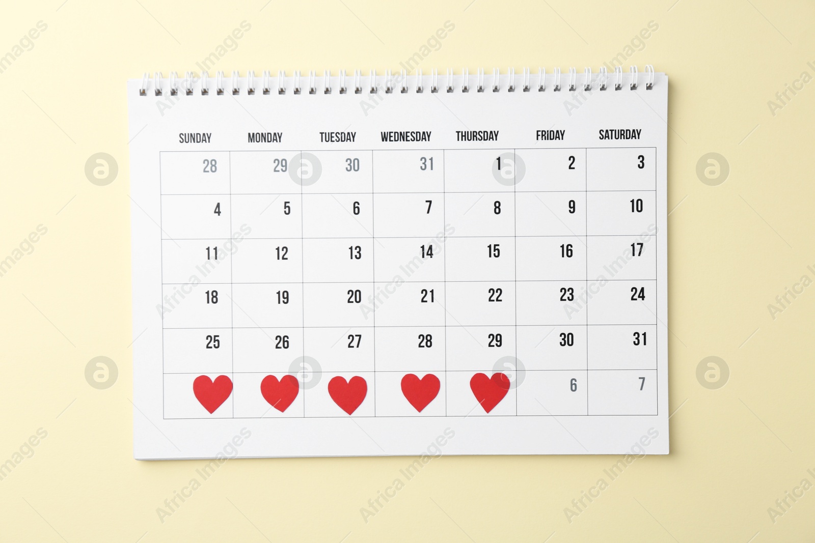 Photo of Menstruation. Calendar with marked dates on beige background, top view