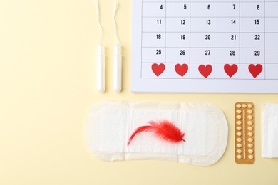 Photo of Flat lay composition with calendar and menstrual products on beige background