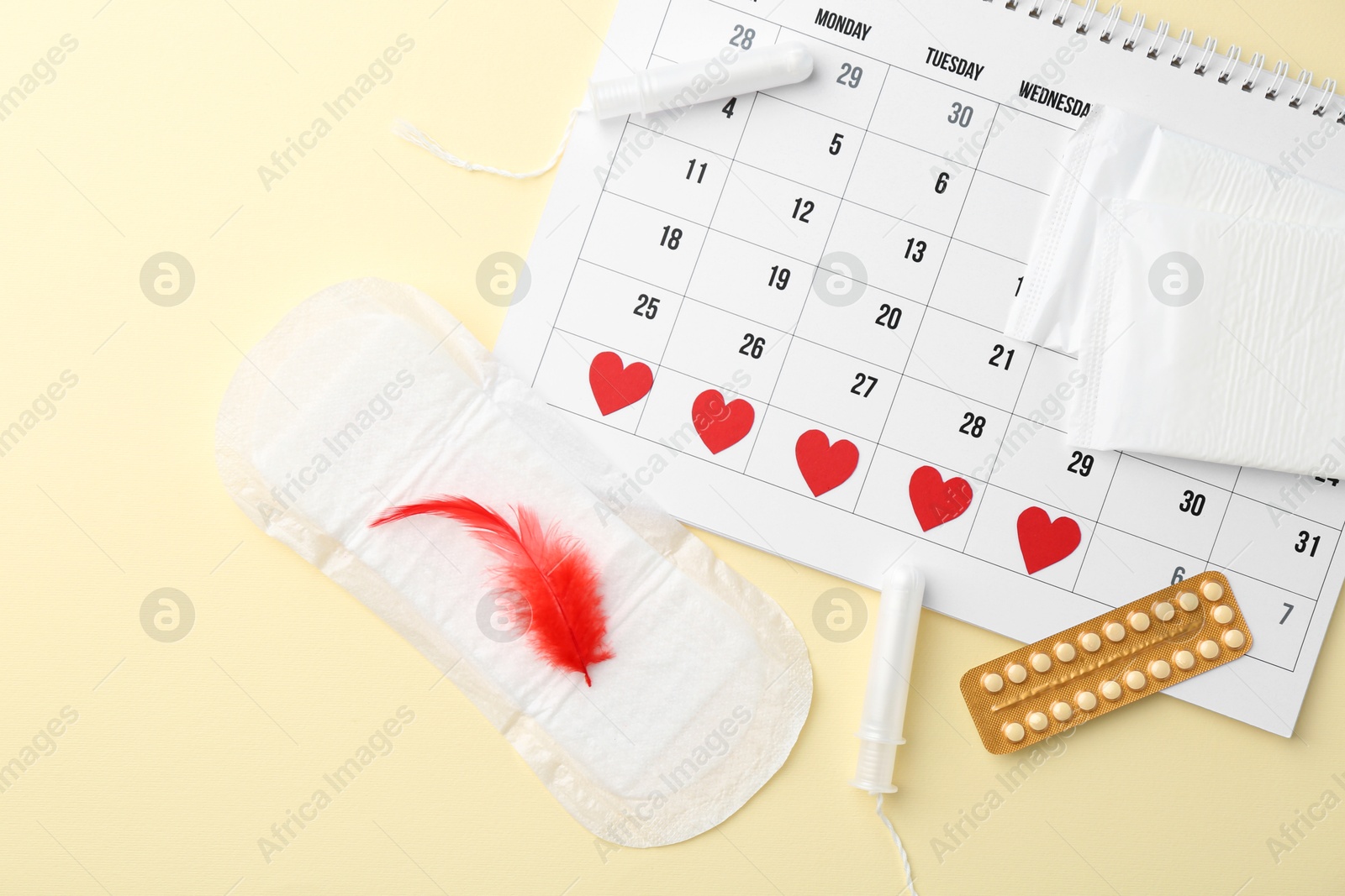 Photo of Flat lay composition with calendar and menstrual products on beige background