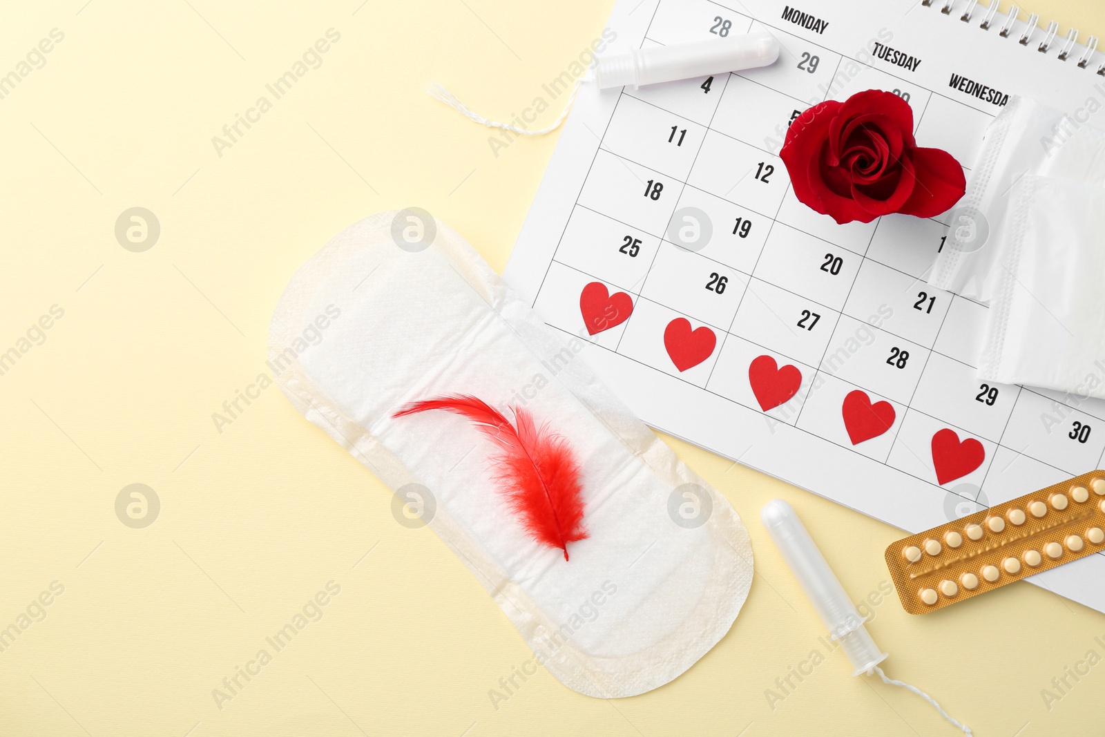 Photo of Flat lay composition with calendar and menstrual products on beige background