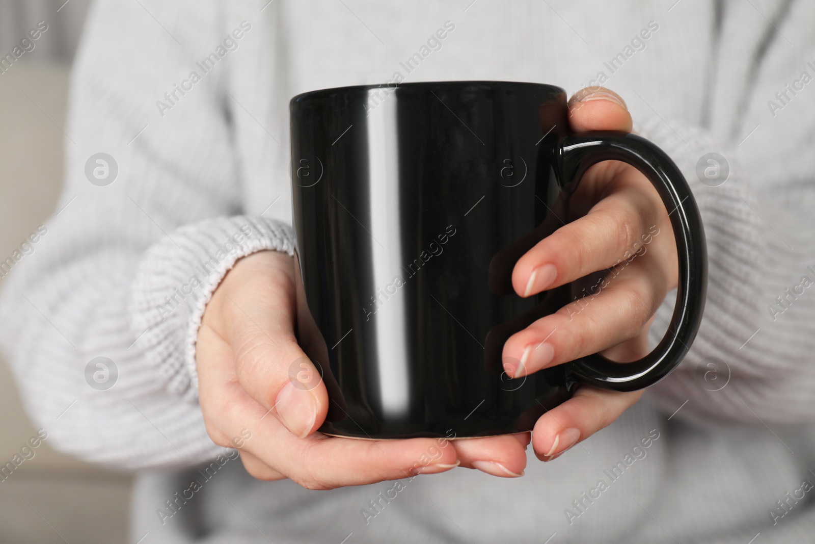 Photo of Woman with black ceramic cup, closeup. Mockup for design