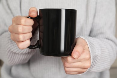 Photo of Woman with black ceramic cup, closeup. Mockup for design