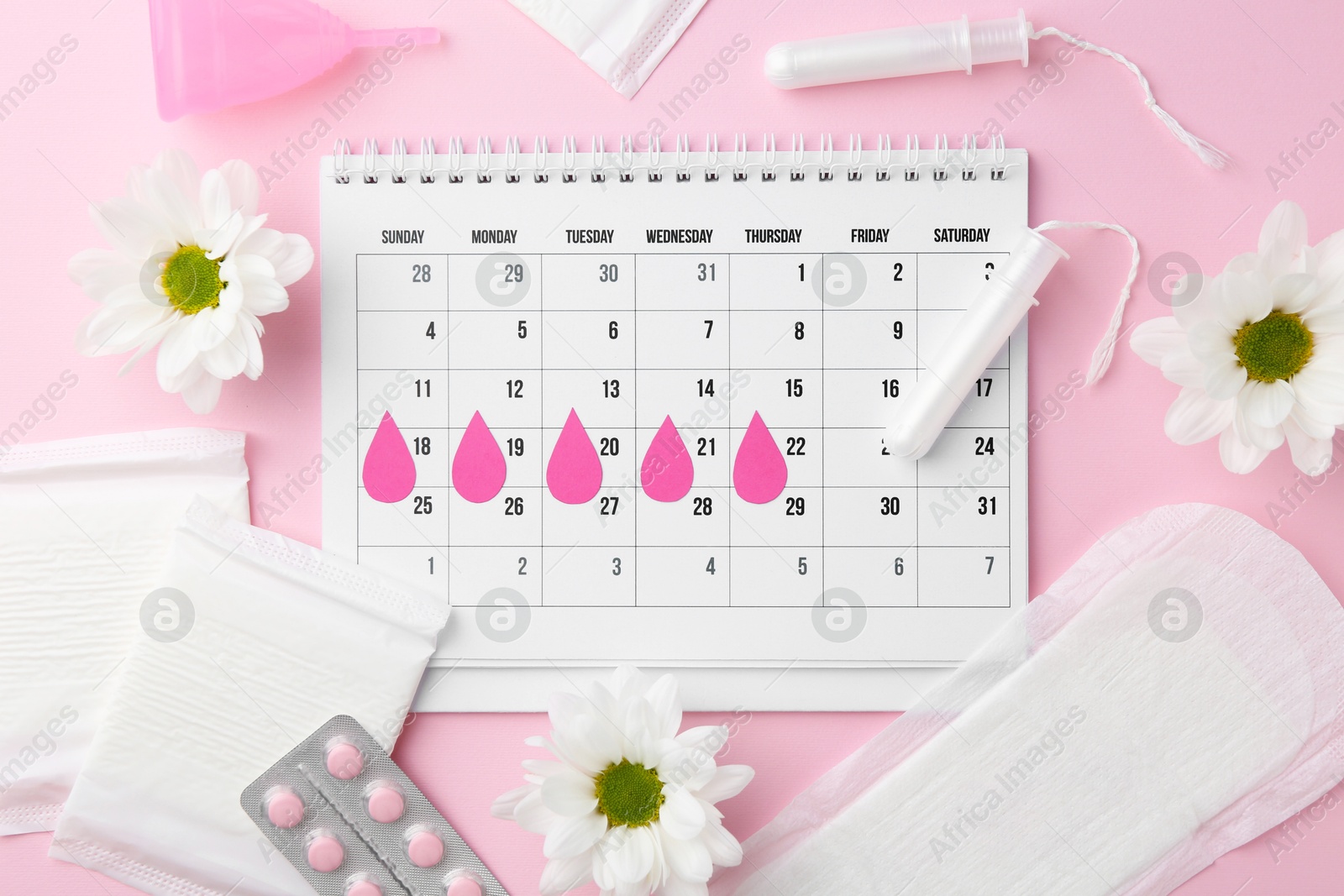 Photo of Flat lay composition with calendar and menstrual products on pink background