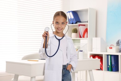 Photo of Girl with stethoscope pretending to be doctor indoors