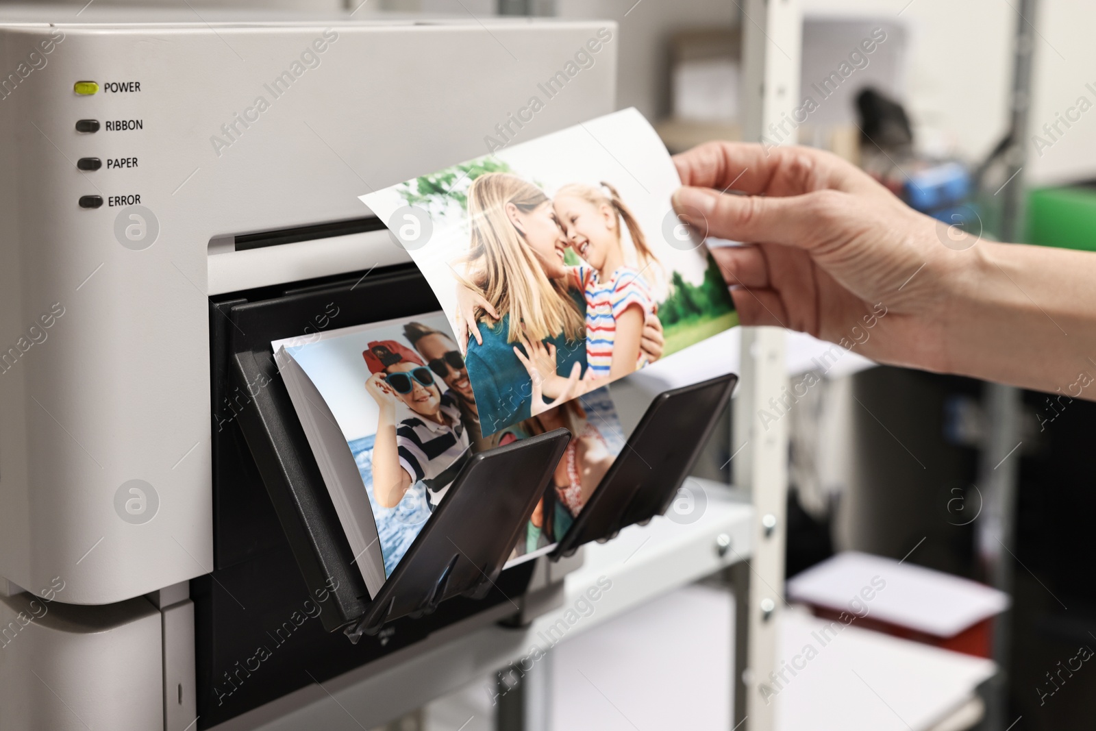 Photo of Woman with colorful photos near modern printer indoors, closeup