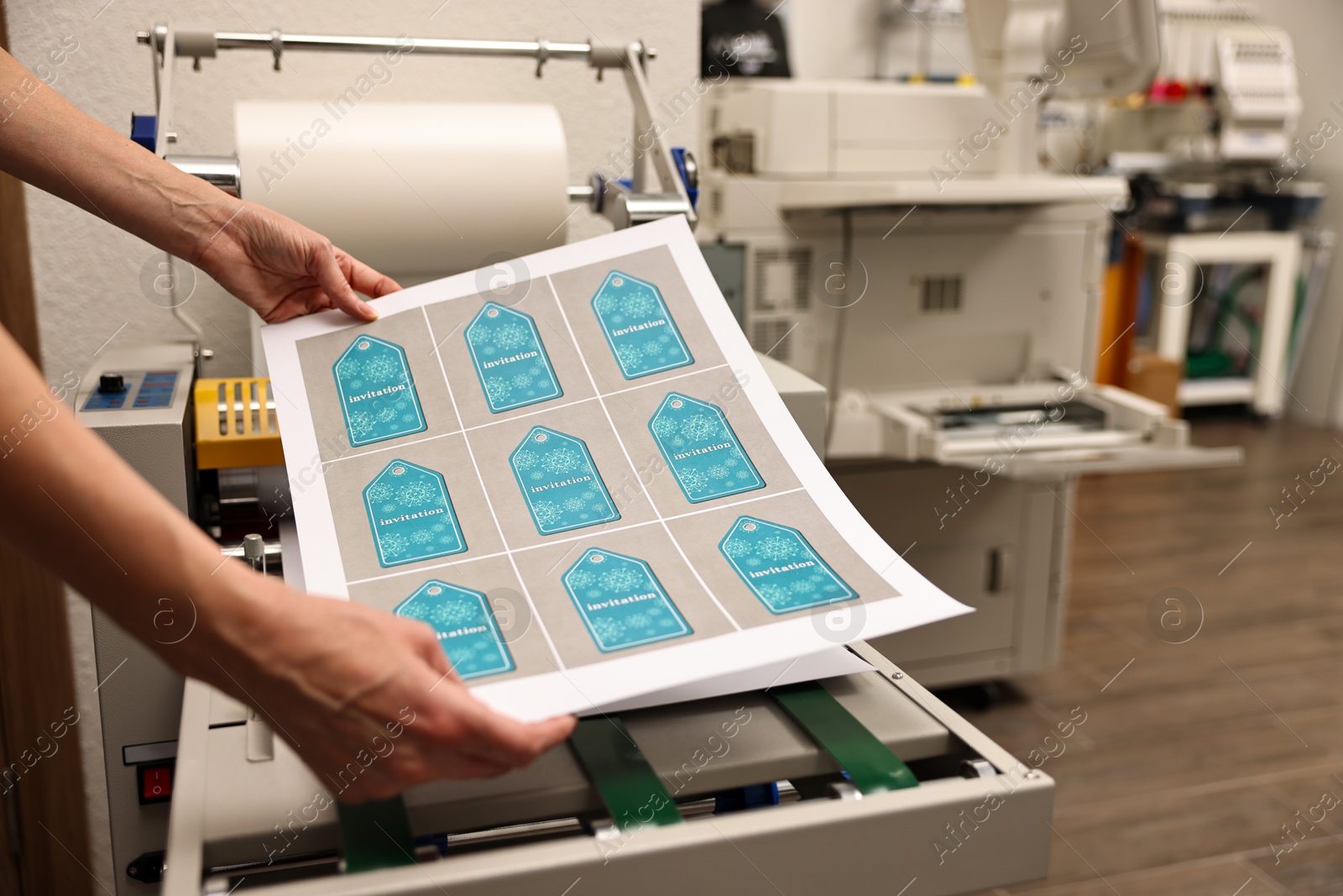 Photo of Woman with printed invitation tags indoors, closeup. Printing house