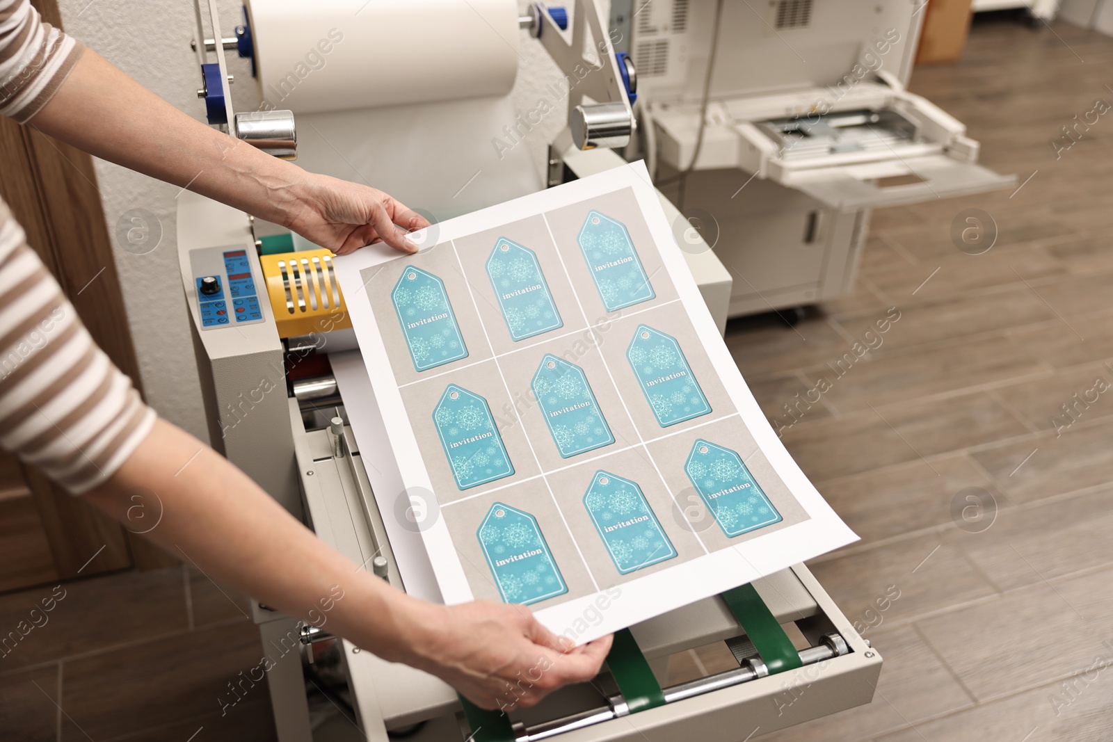 Photo of Woman with printed invitation tags indoors, closeup. Printing house