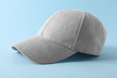 Photo of Stylish baseball cap on light blue background, closeup. Mockup for design